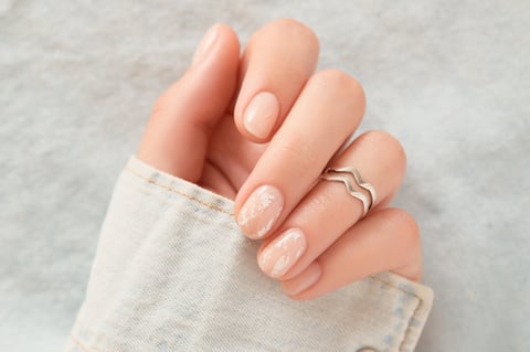 Woman getting nail manicure at spa centre with beautiful nail design